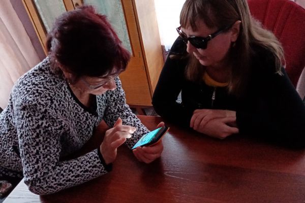 Вялых В.А. обучает пользоваться сенсорным телефоном Хилько В.И.