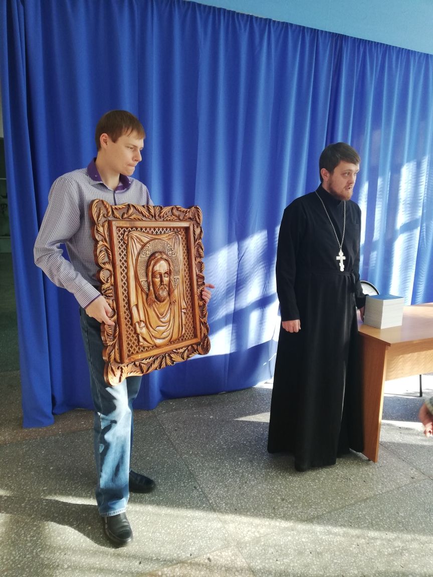 Служитель собора дарит икону Иисуса Христа