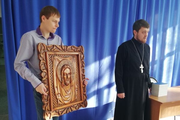 Служитель собора дарит икону Иисуса Христа