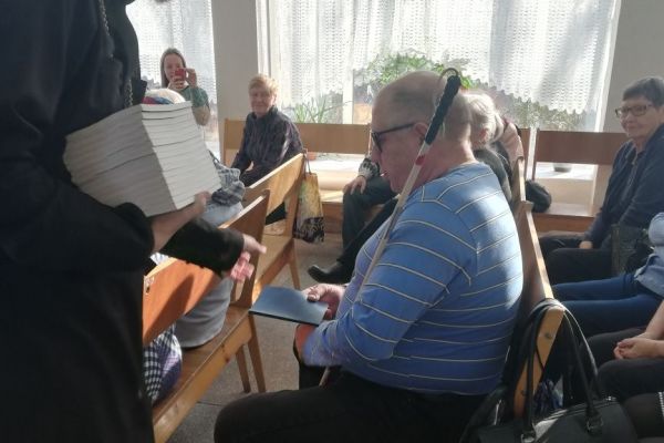 Служитель собора вручает книги 