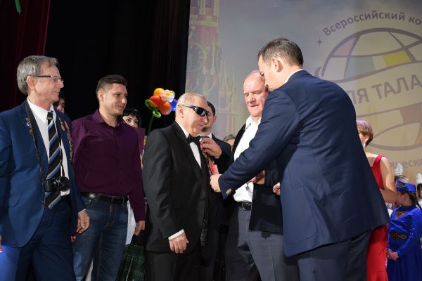Лидер КПРФ  вручает награду