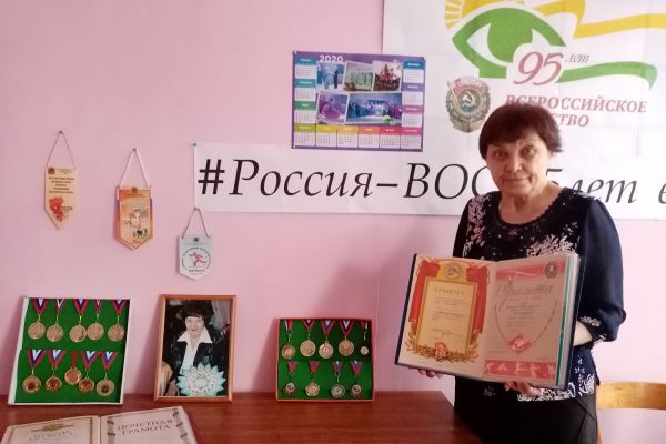 Любовь Ивановна представляет  выставку наград.